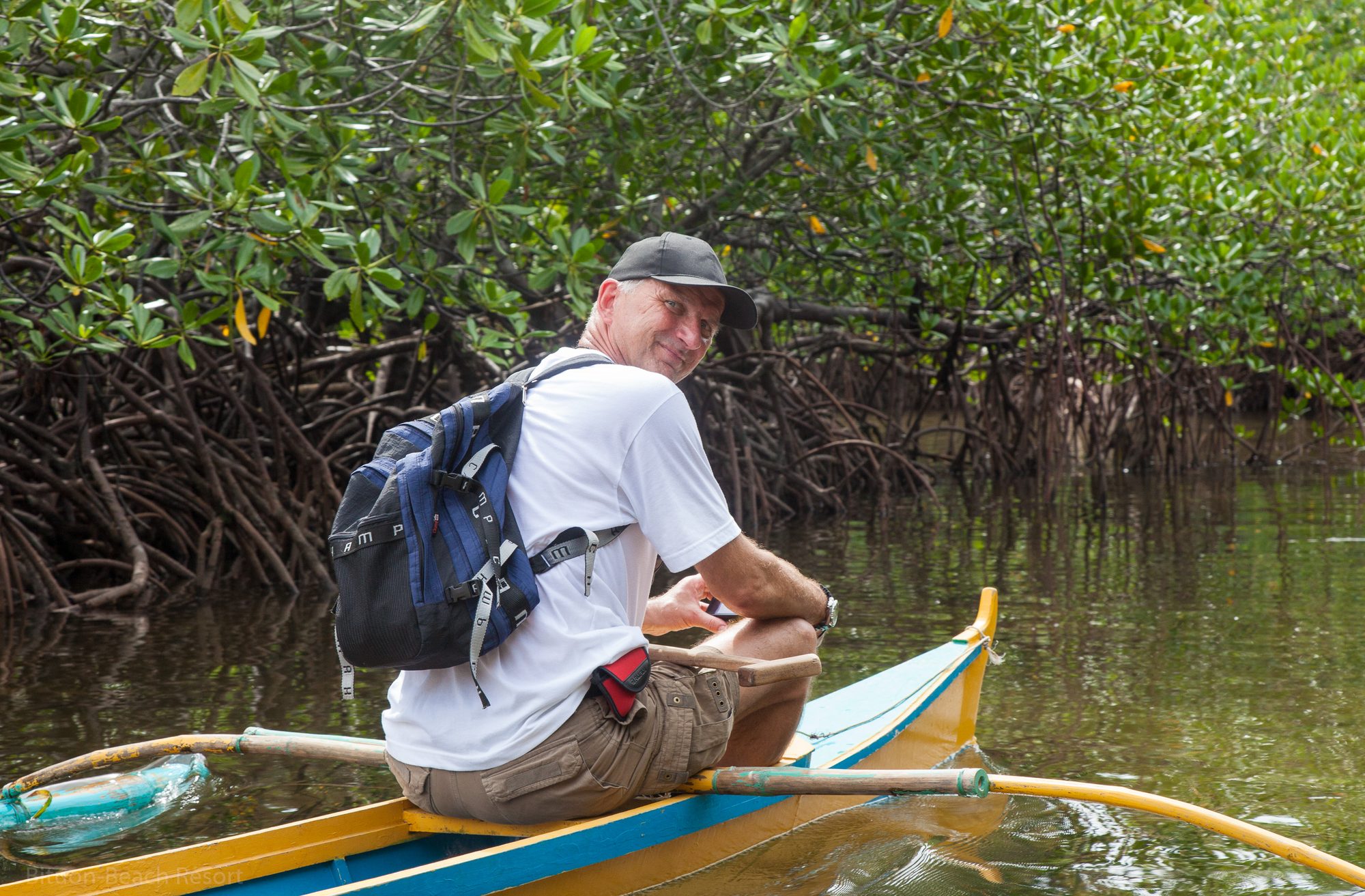Gast im Auslegerboot fährt durch die Mangroven nahe Lamanok Island während der geführten Tour.