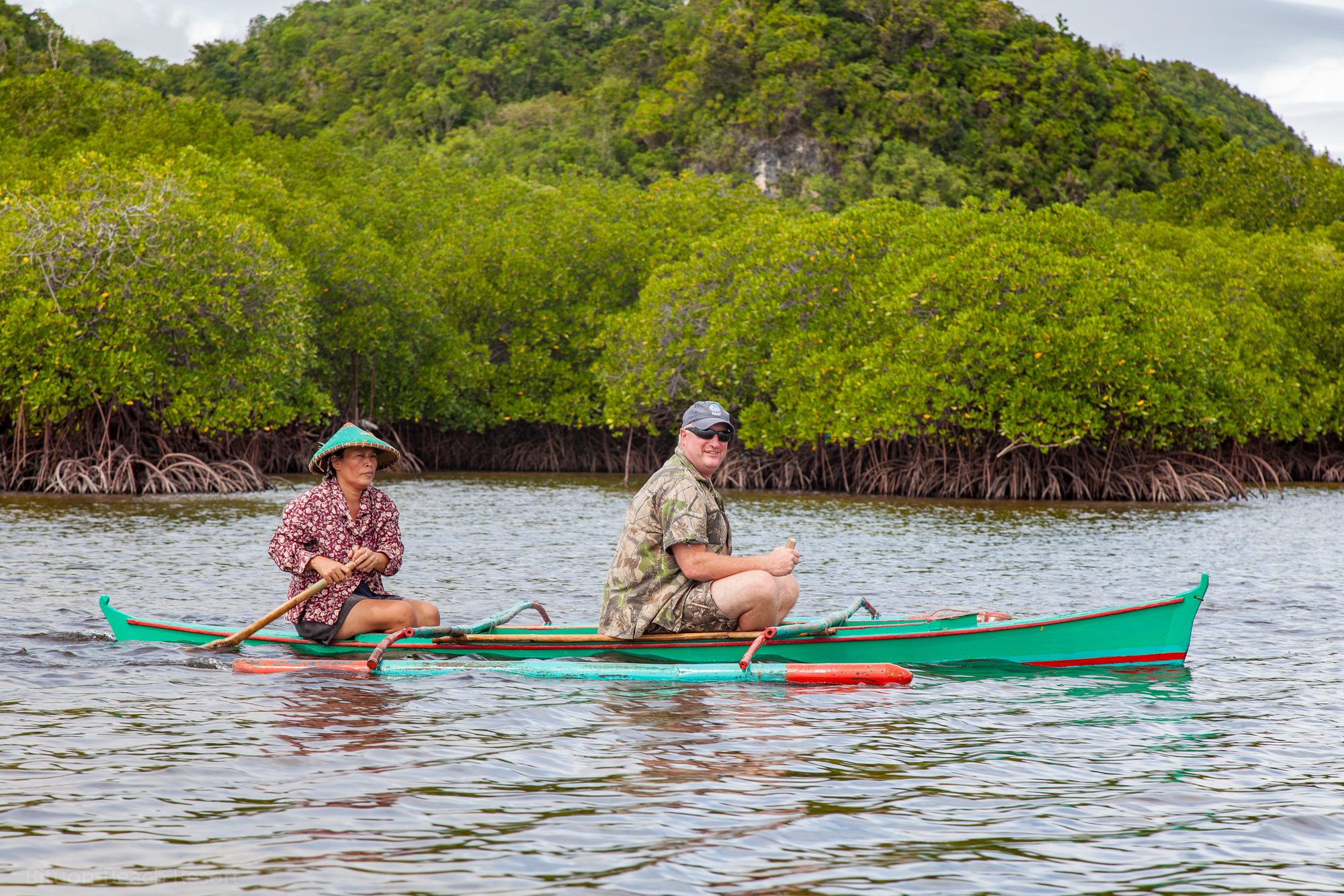 Gast im traditionellen Auslegerboot mit lokaler Bootsführerin in den Mangroven bei Lamanok Island.